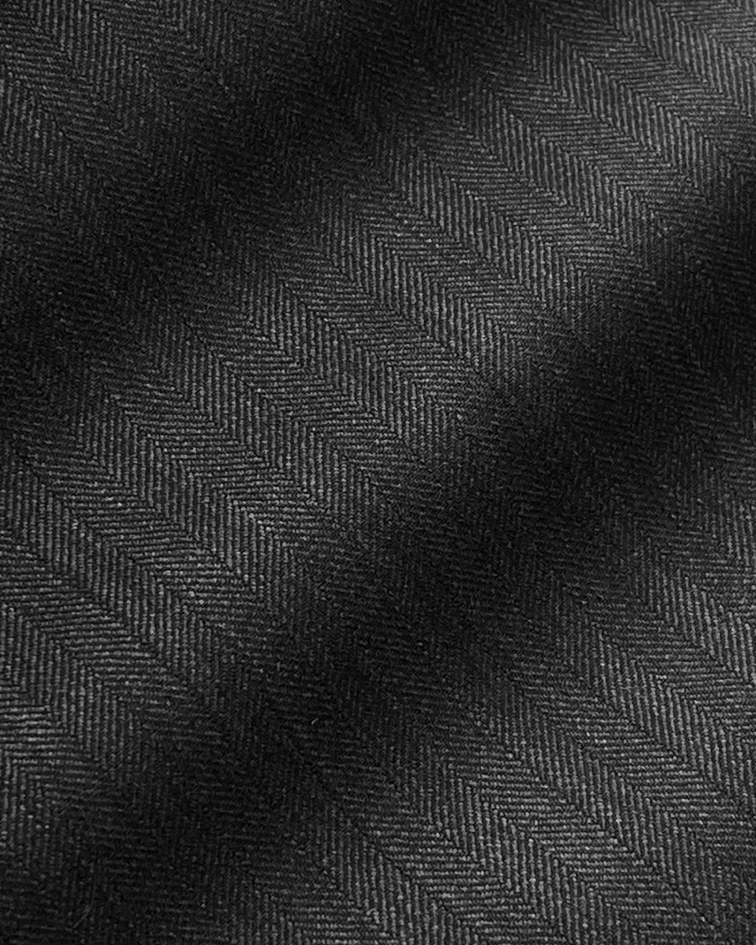 Dark herringbone fabric close-up, showcasing detailed texture and pattern.