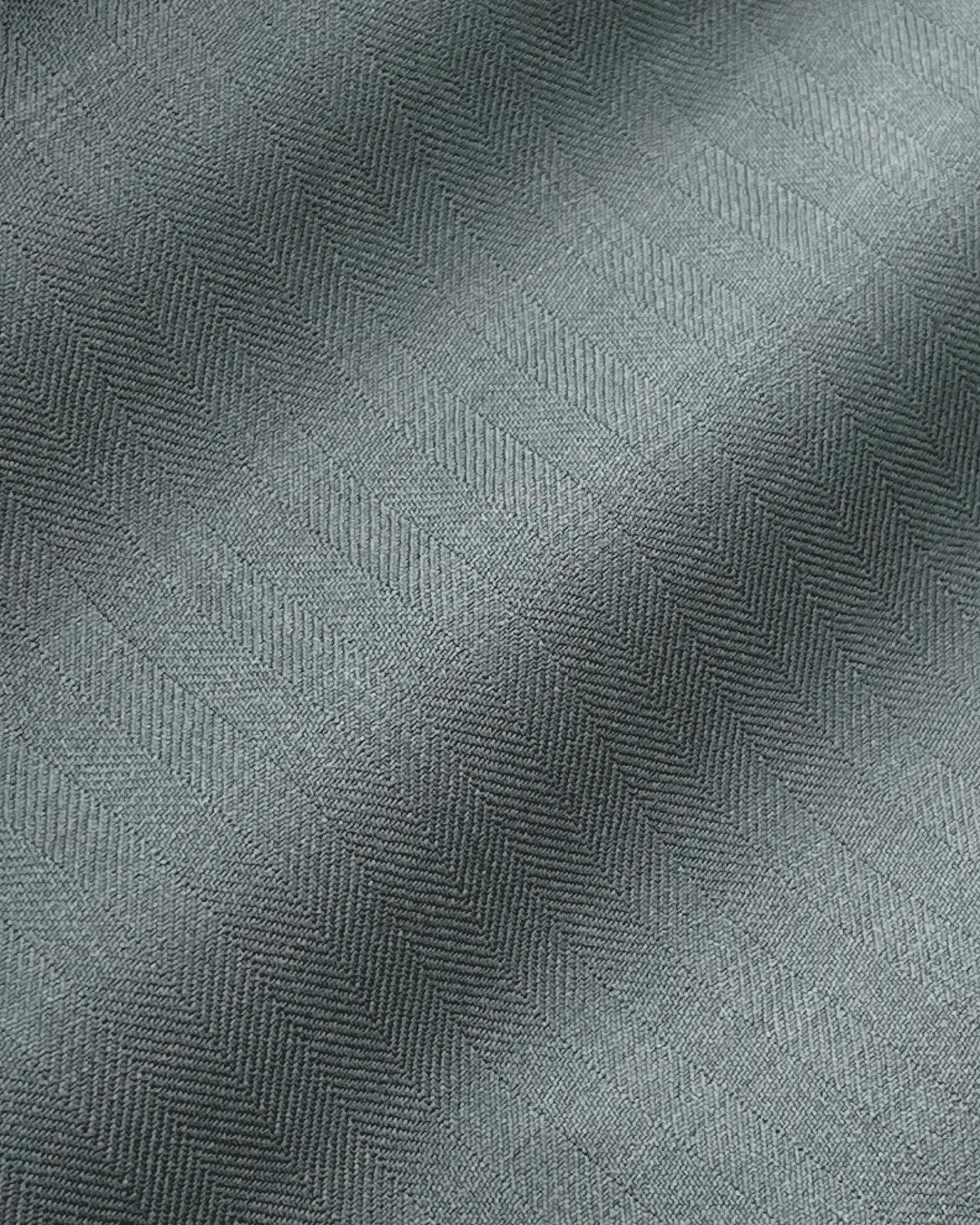 Close-up of grey herringbone fabric texture with subtle pattern, ideal for upholstery or apparel.