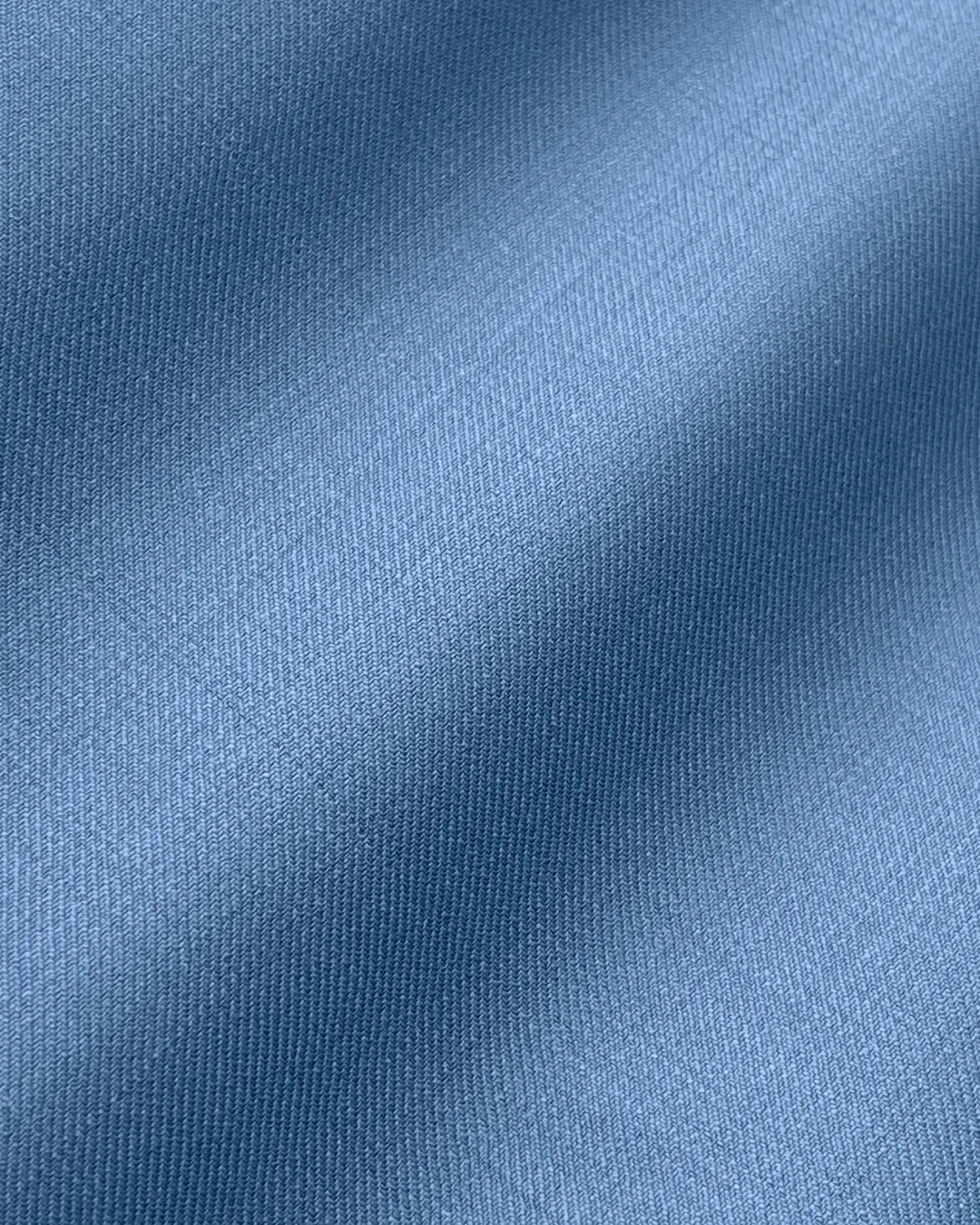 Smooth blue fabric texture with gentle shadows, ideal for textile and design backgrounds.