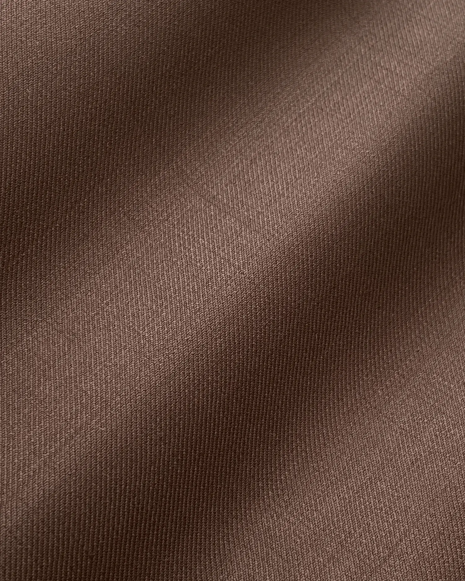 Close-up of brown textured fabric with subtle waves, highlighting its soft and smooth surface.