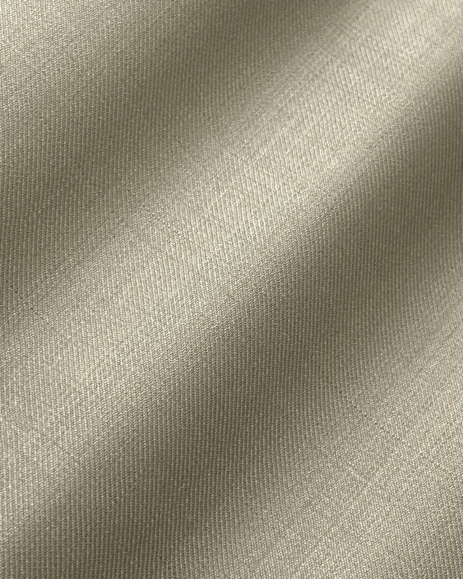 Smooth beige fabric texture with gentle light reflections, showcasing fine weave and soft material surface.