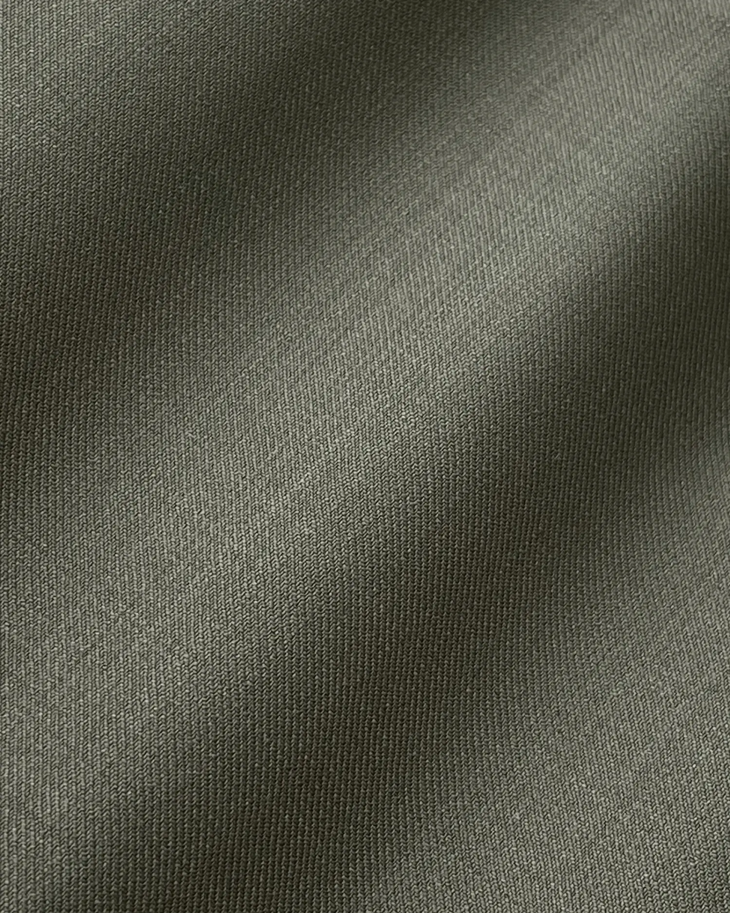 Close-up of dark gray fabric texture with a soft, smooth appearance, showing fine weave and subtle shadows.