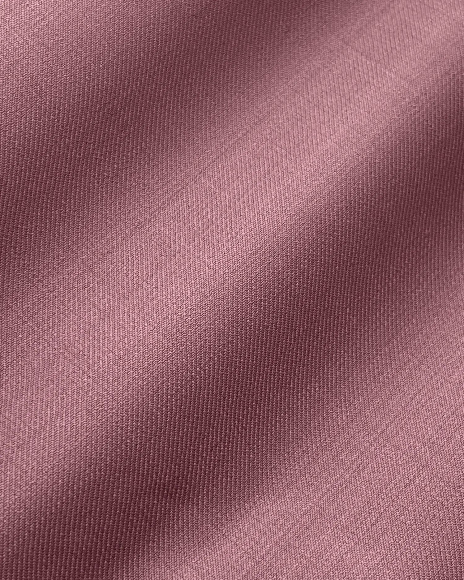 Close-up of mauve colored fabric texture, perfect for fashion and design backgrounds.