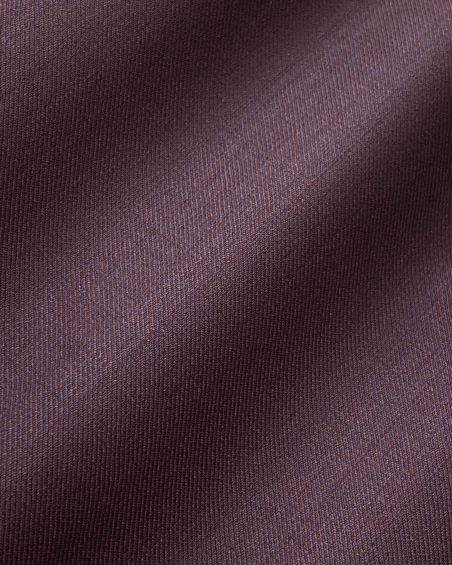 Close-up of smooth, flowing brown fabric texture with subtle waves and soft lighting.