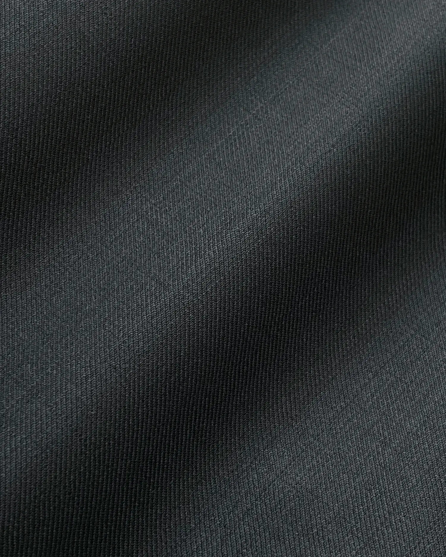 Close-up of textured dark gray textile fabric with subtle diagonal ridges, highlighting fine details and smooth surface.