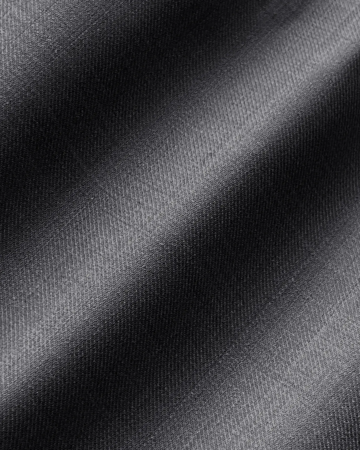 Close-up of smooth, dark fabric texture with subtle diagonal lines. Ideal for textile or fashion design concepts.