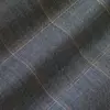 Close-up view of blue tweed fabric with beige grid pattern, ideal for clothing and upholstery design.