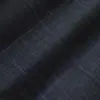 Close-up of dark blue, grid-patterned textile fabric texture.