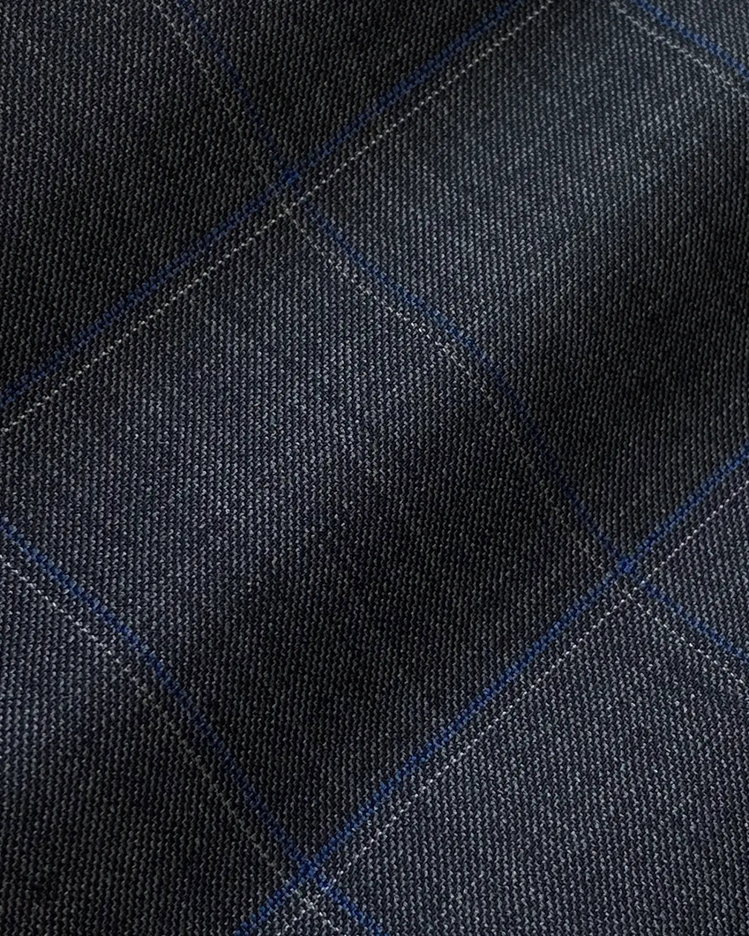 Close-up of dark blue, grid-patterned textile fabric texture.