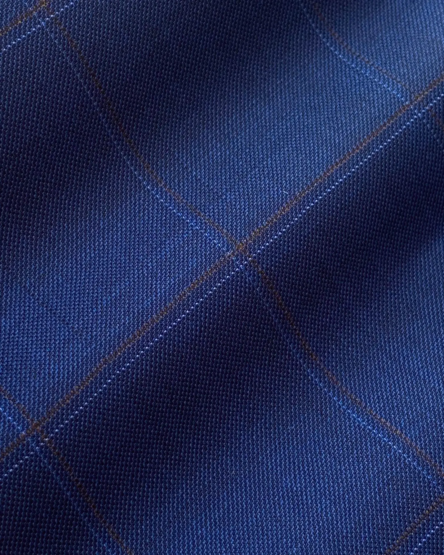 Blue plaid fabric texture with detailed weave, showcasing intersecting lines and a soft shadow effect. Perfect for fashion design.