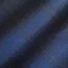 Close-up of dark blue plaid fabric with textured pattern and intersecting gold lines.