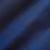 Close-up of blue plaid fabric with intersecting lines, showcasing a textured pattern ideal for fashion or upholstery design.
