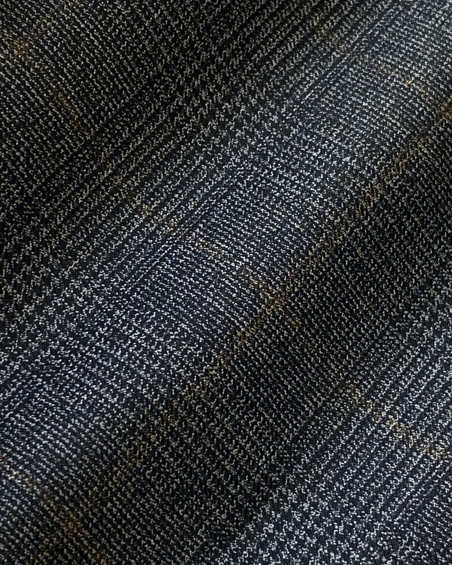 Close-up of dark gray plaid fabric with a subtle checkered pattern.