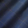 Close-up of blue and black plaid fabric with intricate patterns and textures.