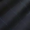 Close-up of black fabric with blue grid pattern, showing texture and stitching detail. Ideal for fashion or design themes.