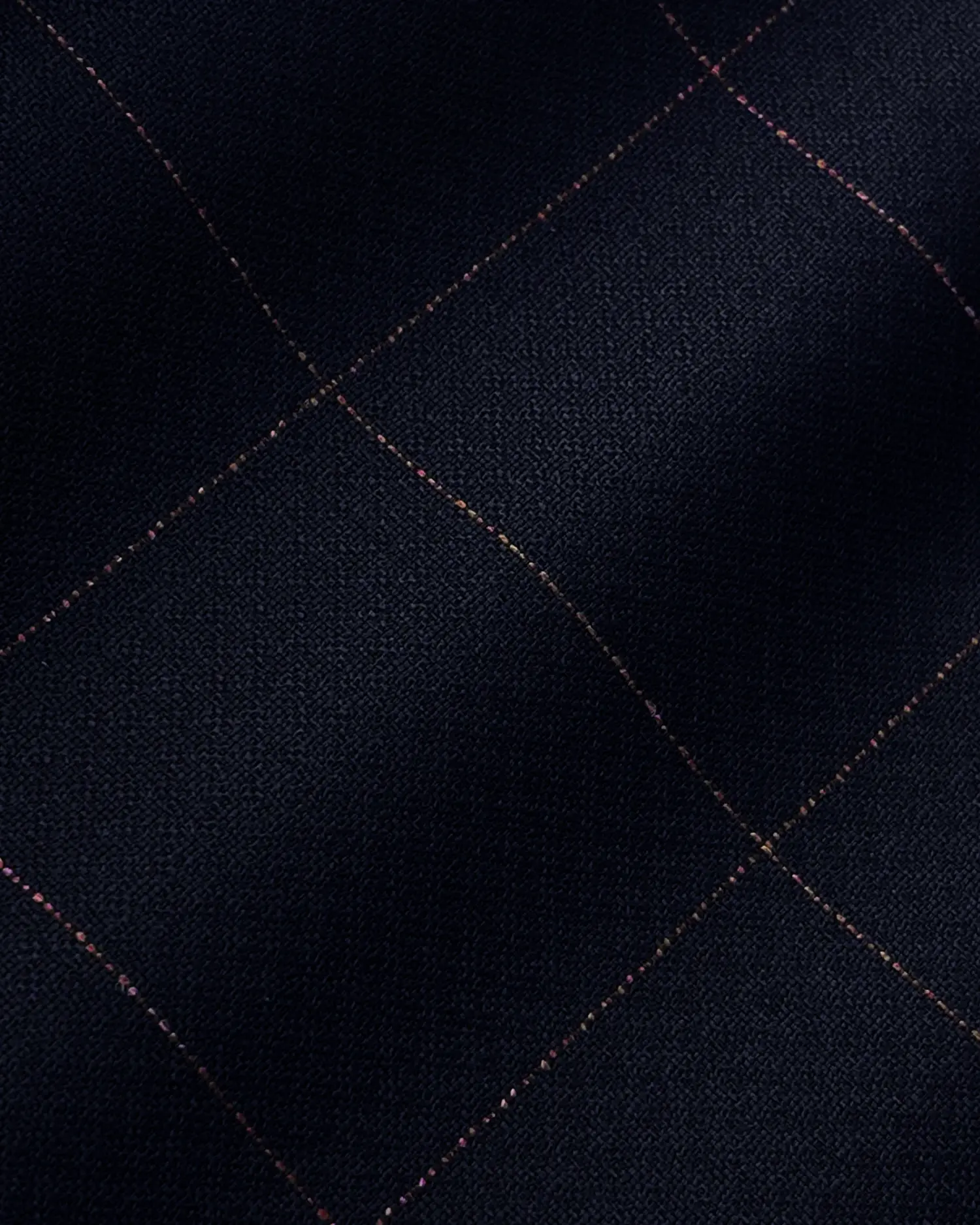 Close-up of dark checkered fabric with subtle red and blue lines, showcasing textured textile pattern.