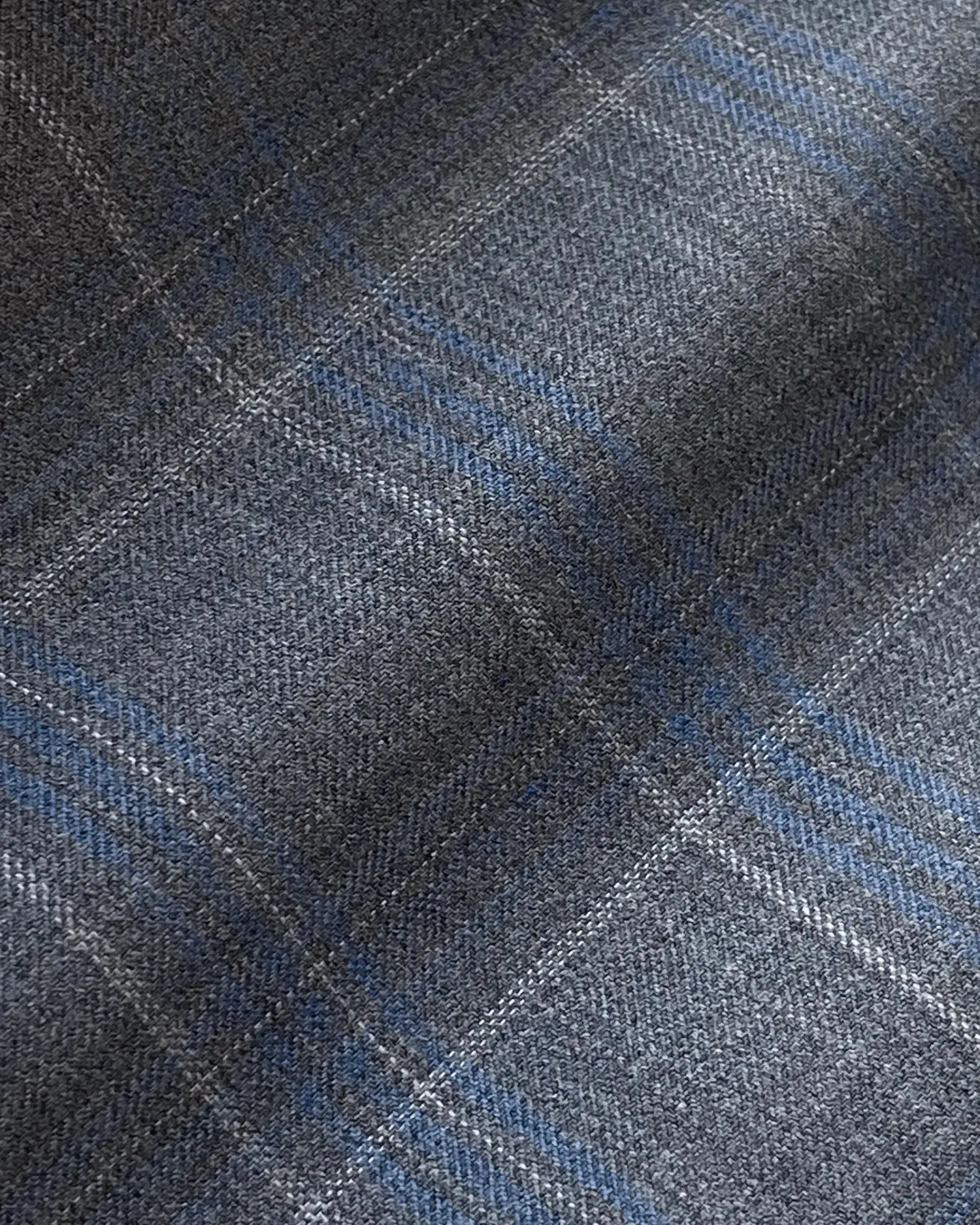 Close-up of a gray and blue plaid fabric pattern, perfect for winter fashion or upholstery design.