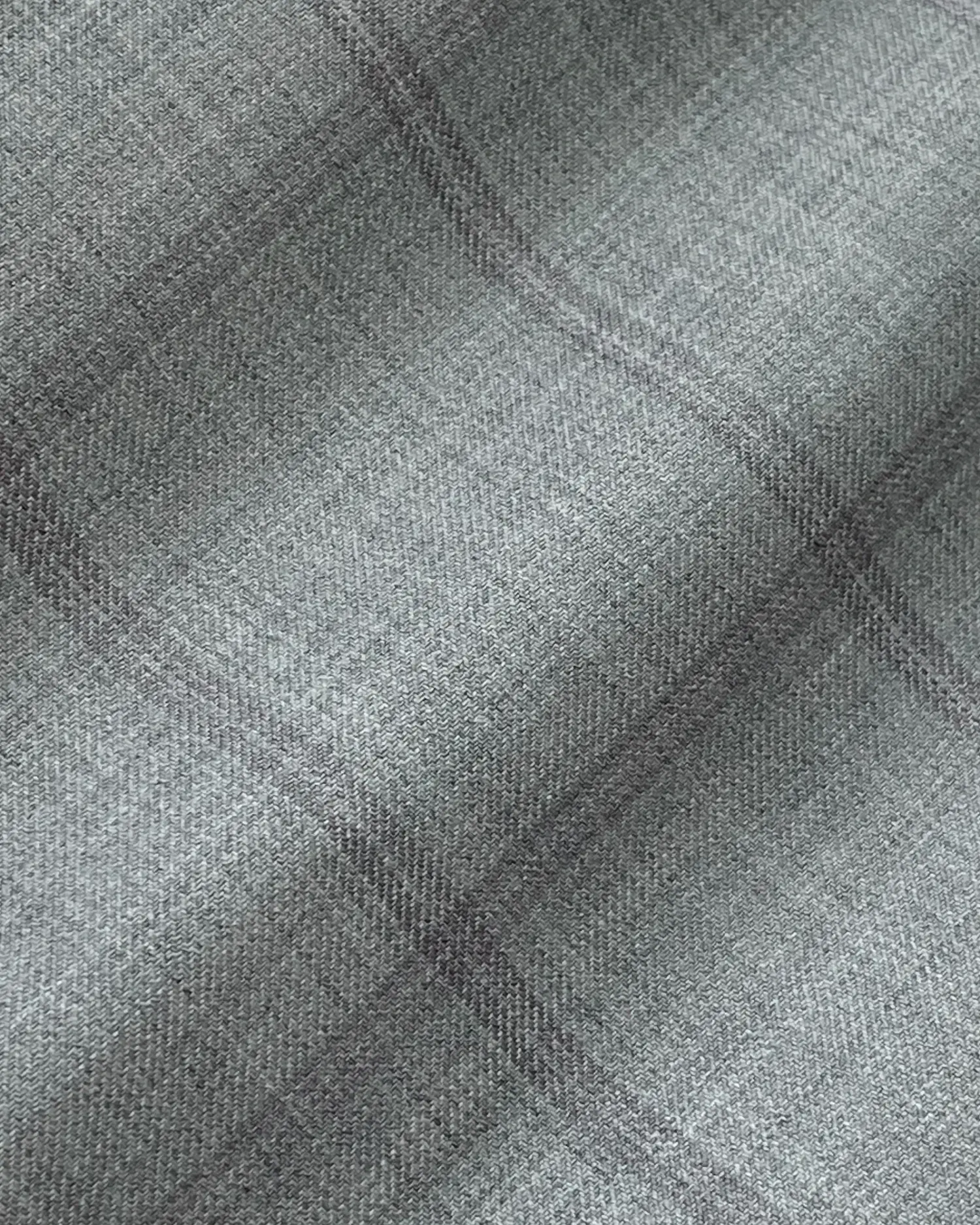 Close-up of gray textured fabric with subtle plaid pattern, ideal for upholstery or fashion design.