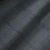 Close-up of gray plaid textured fabric with subtle lines and soft shadows.