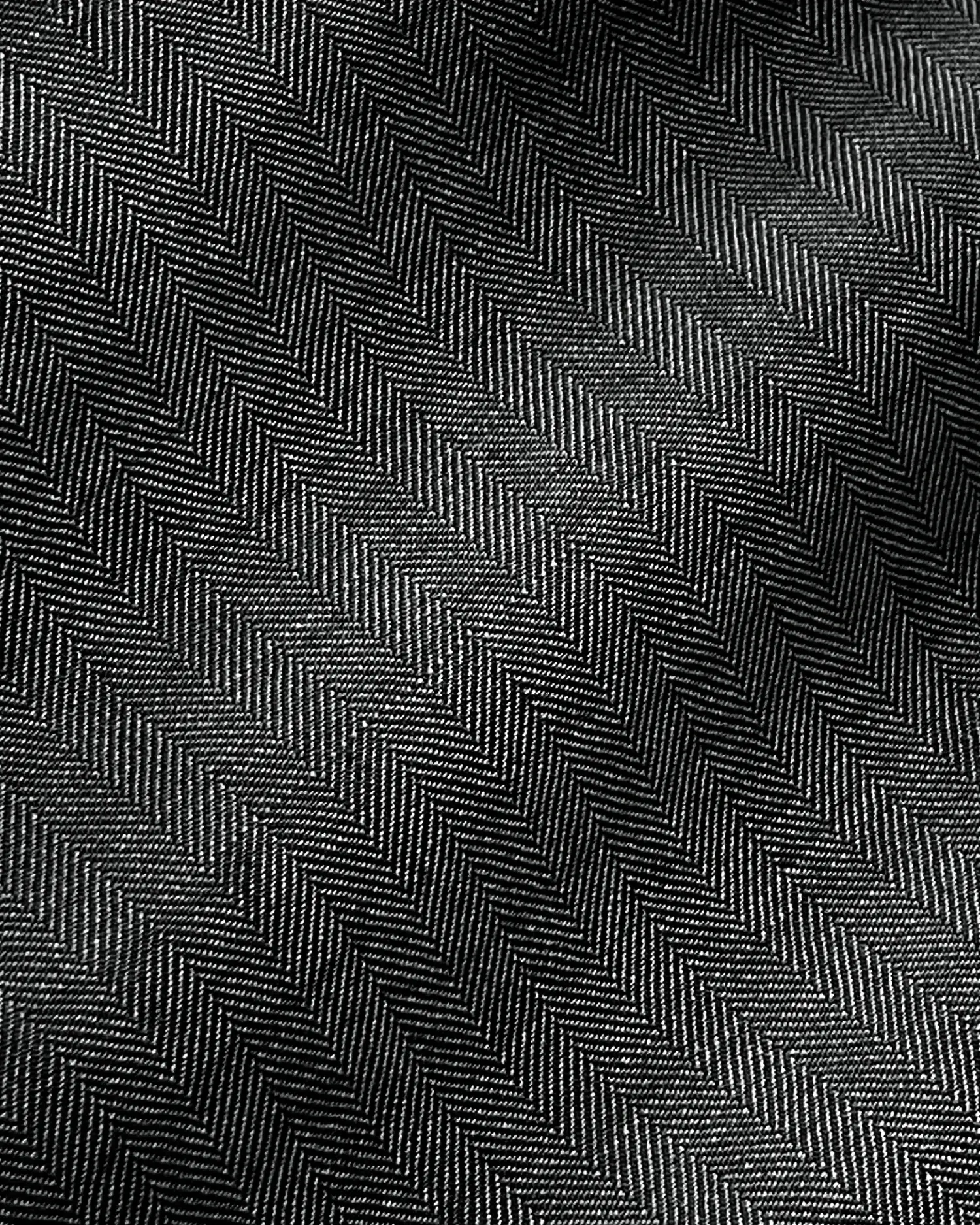 Close-up of black and white herringbone fabric texture with detailed zigzag pattern.