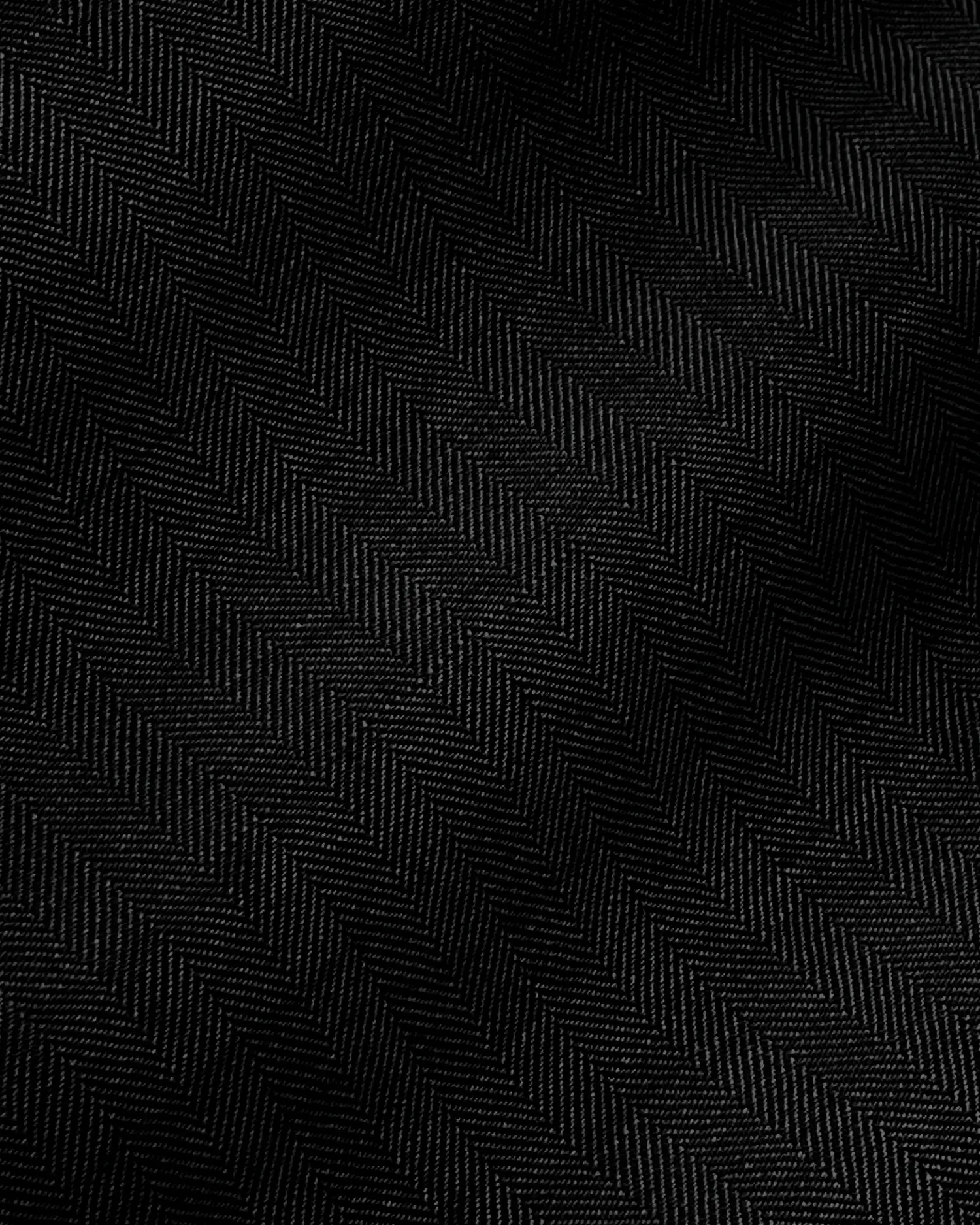 Close-up of black fabric with a subtle herringbone pattern and a soft texture.