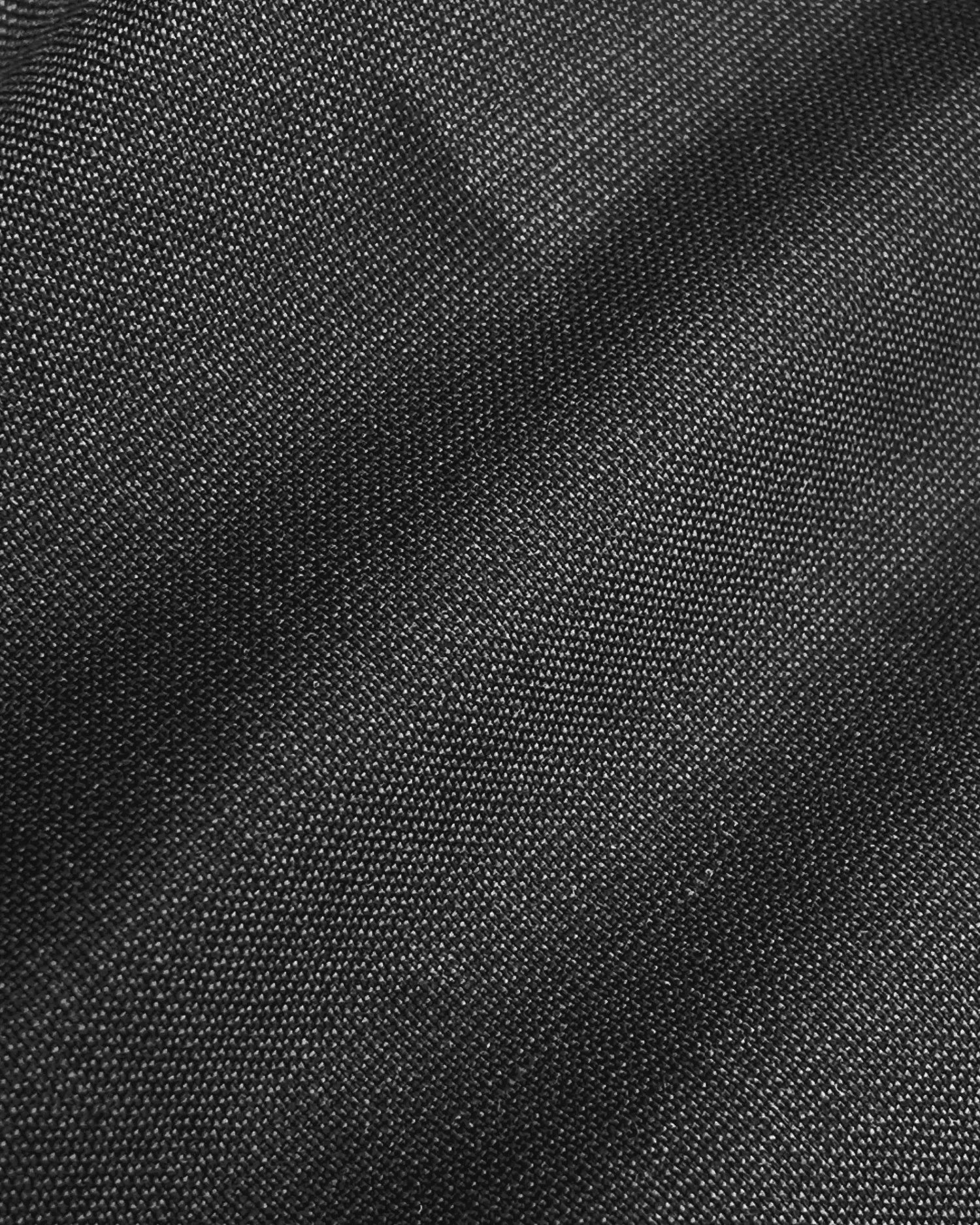 Close-up of black denim fabric with visible texture and weave.