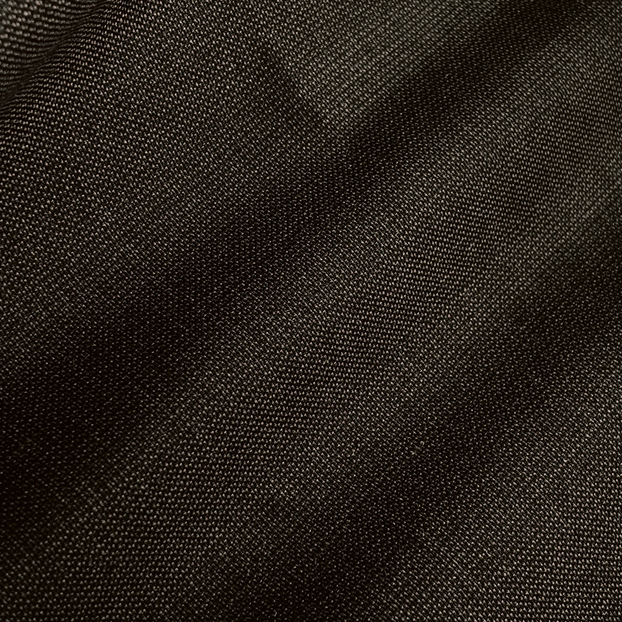 Close-up of dark woven fabric texture, showing detailed cross-thread pattern and subtle sheen.