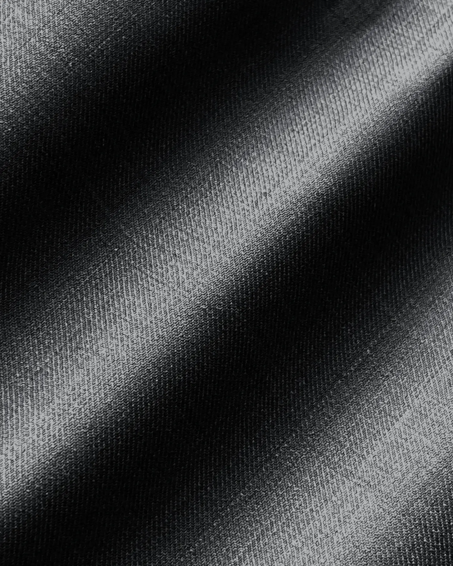 Close-up of black textured fabric with diagonal patterns and subtle shading.