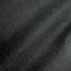 Close-up of black herringbone fabric texture with diagonal pattern, highlighting detailed textile surface design.
