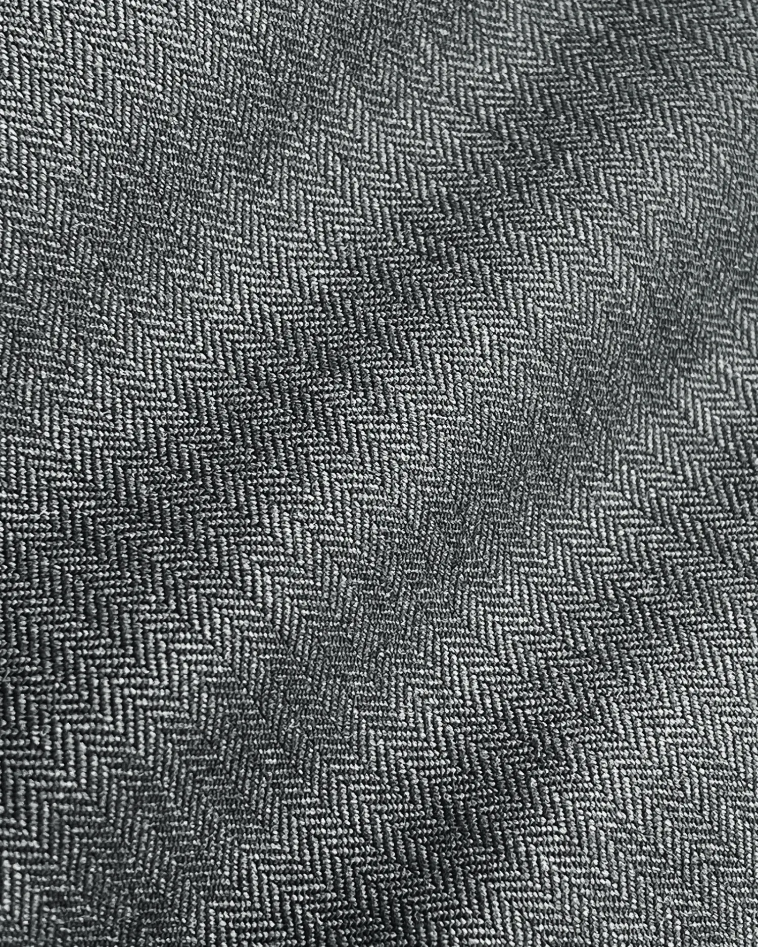 Gray herringbone patterned fabric close-up, showcasing detailed texture for design and fashion inspiration.