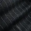 Close-up of dark fabric with subtle vertical pinstripes, showing texture details and pattern.