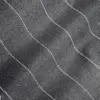 Close-up of black fabric with wavy white stitching, showcasing texture and pattern detail.