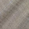 Close-up of a textured brown fabric with a subtle diagonal pattern and fine blue lines.