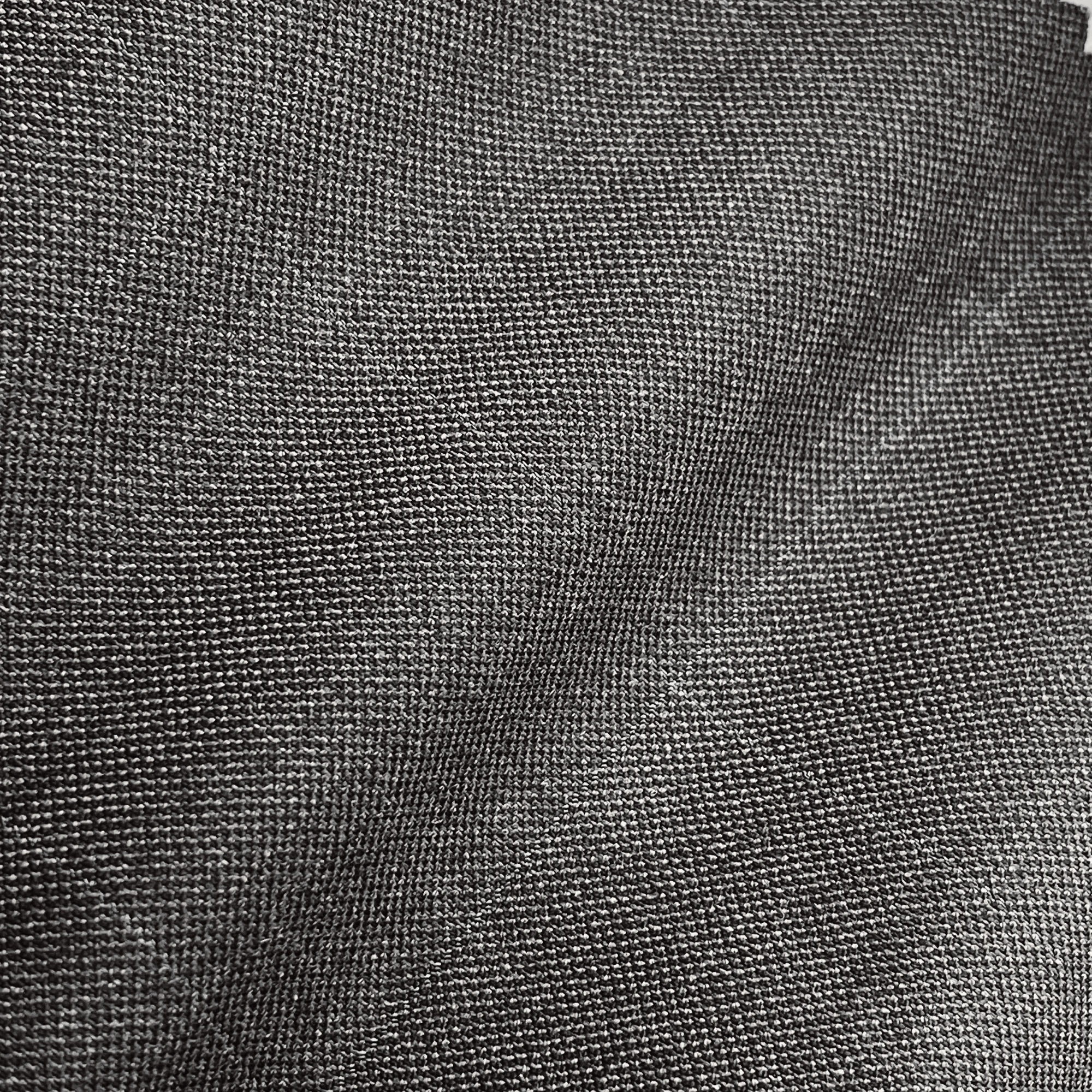 Close-up of a textured dark fabric with a subtle sheen, showing detailed weave pattern. Ideal for clothing or upholstery.