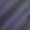 Close-up of a textured fabric with wavy blue and gray lines, highlighting detail and pattern.