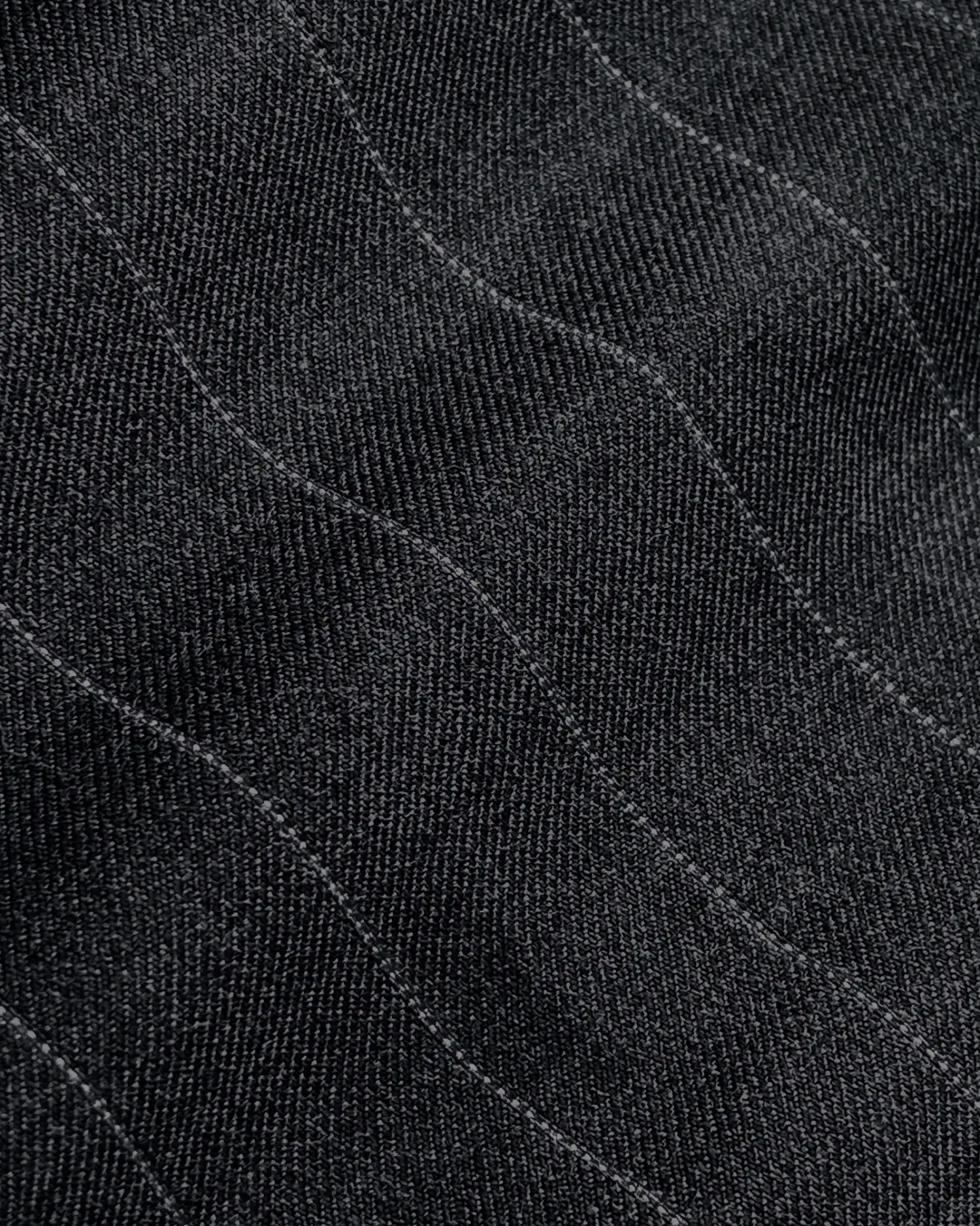Close-up of textured black fabric with subtle curved lines, showcasing intricate stitching and pattern detail.