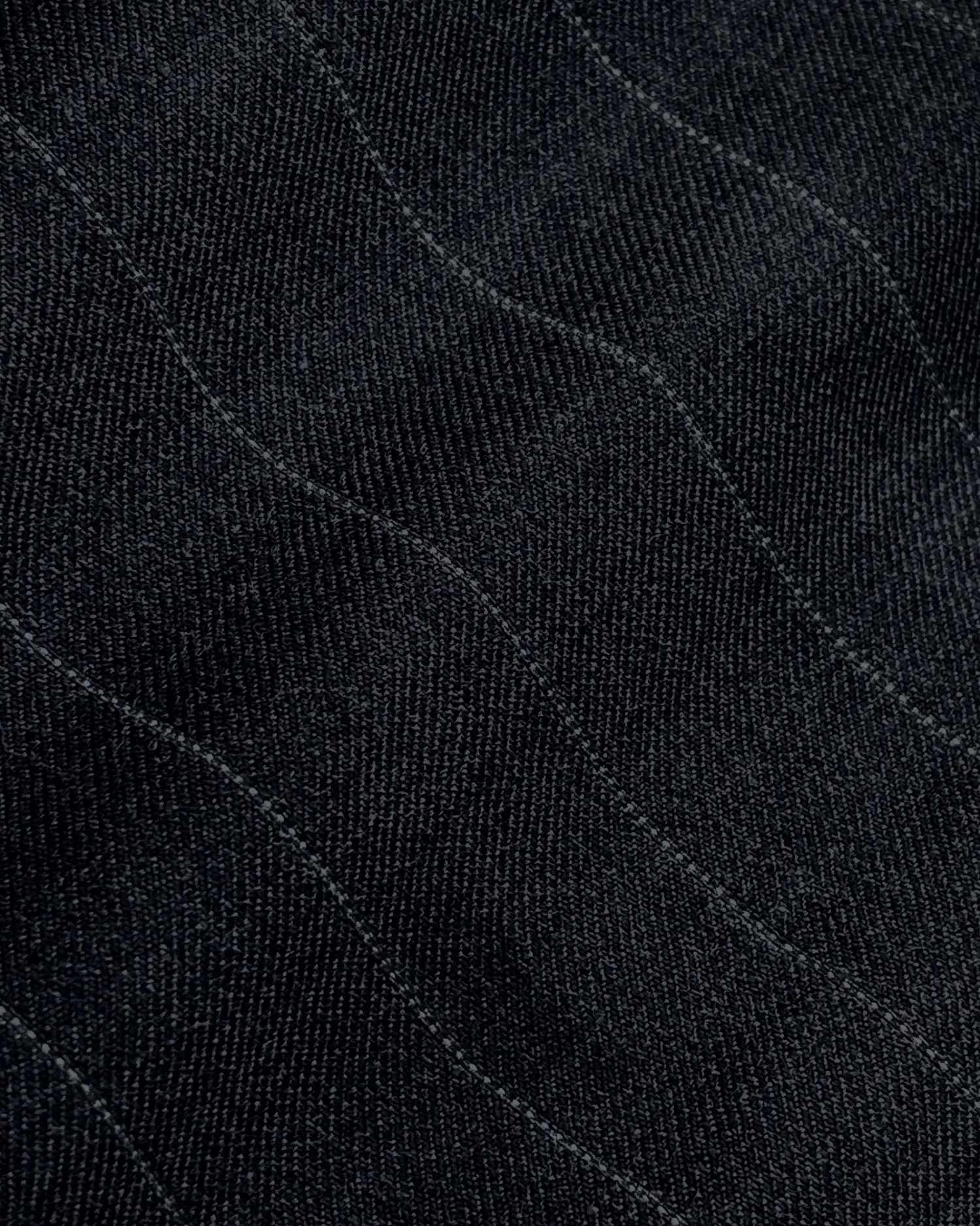 Close-up of black textured fabric with diagonal wave pattern stitches.