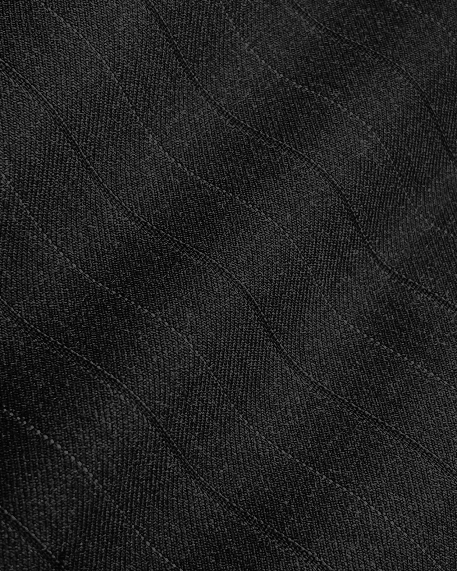 Close-up of black textured fabric with subtle wave patterns. Ideal for fashion and textile design concepts.