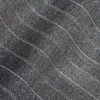 Close-up of textured denim fabric with wavy stitching details, showcasing intricate woven pattern.