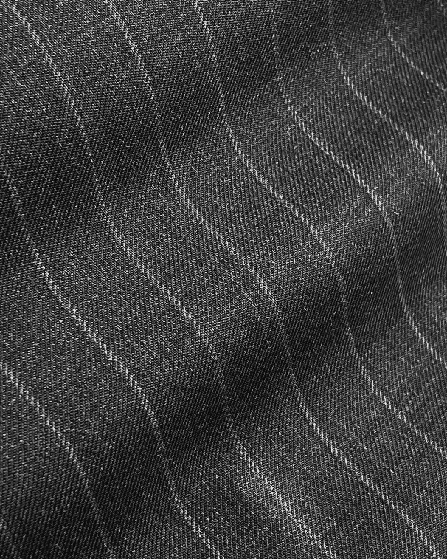 Close-up of gray pinstripe fabric with wavy lines, showcasing texture and pattern details. Ideal for fashion and textile design.
