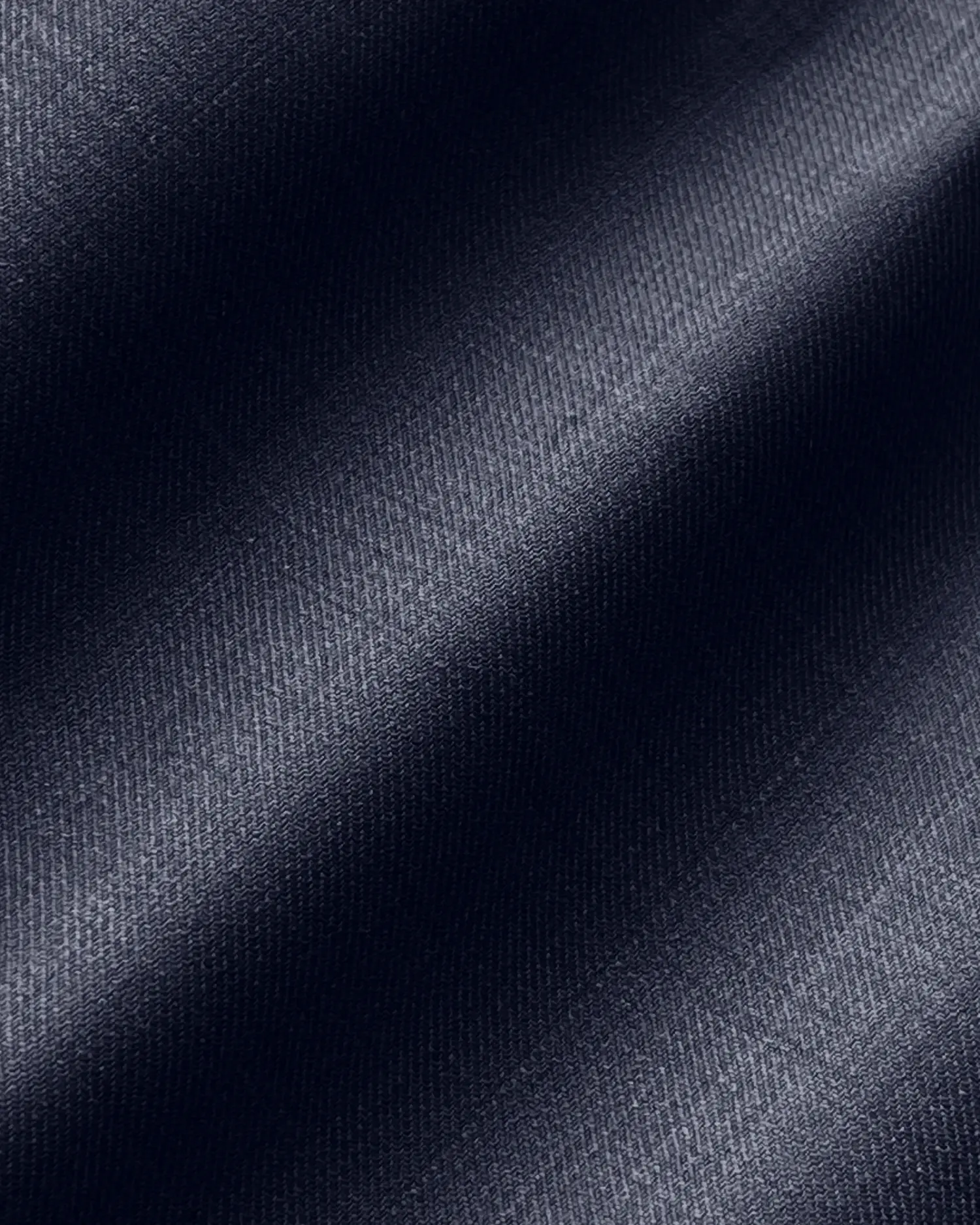 Dark blue satin fabric with smooth, shiny texture and diagonal folds, reflecting light elegantly.