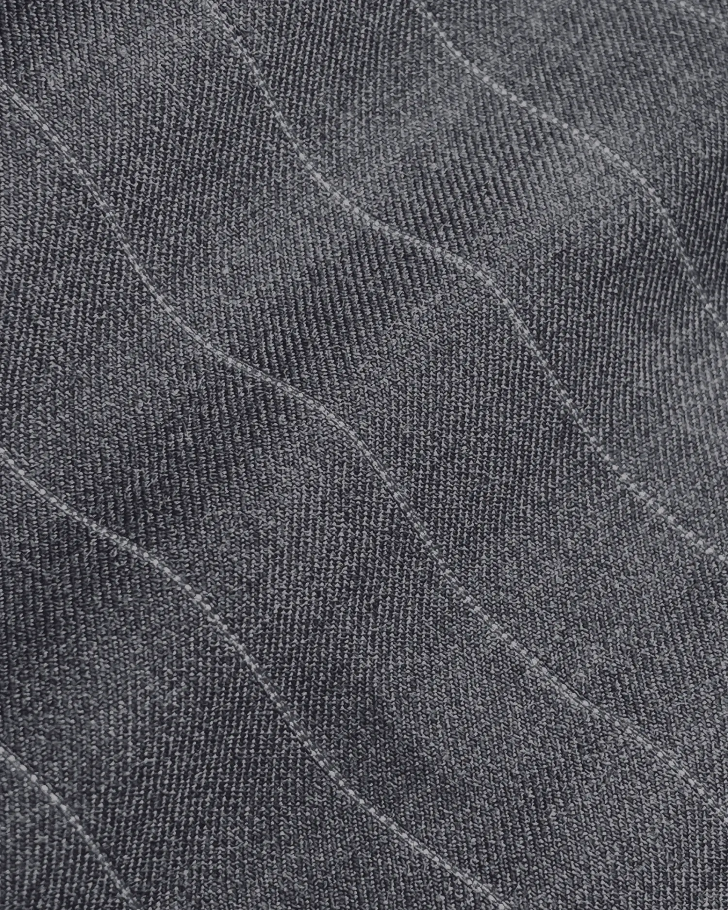 Close-up of gray textured fabric with wavy patterns and fine stitching.