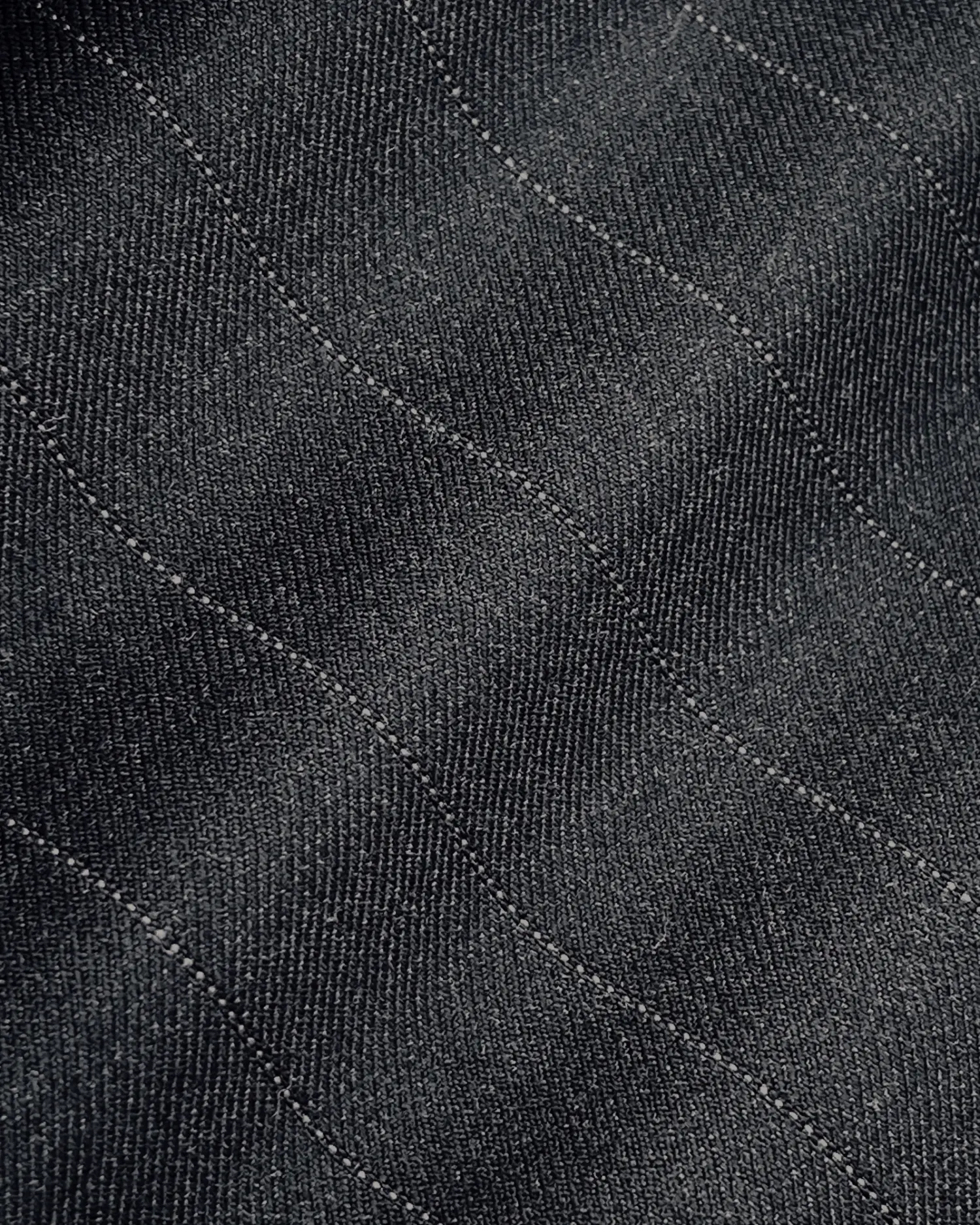 Close-up of dark denim fabric with subtle stitching pattern.