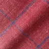 Close-up of red wool fabric with blue check pattern, showcasing texture and detail.