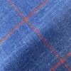 Close-up of blue fabric with red diagonal plaid pattern, highlighting texture and design details.