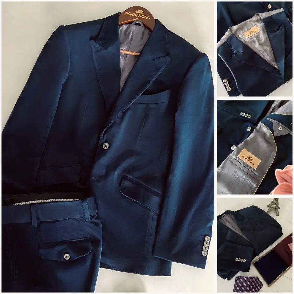 Men's elegant navy blue suit with detailed stitching and luxury label branding, displayed on a white surface.