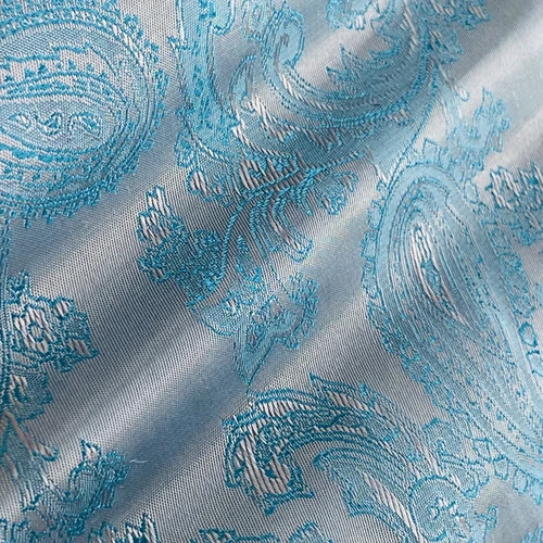 Blue paisley jacquard fabric with intricate pattern. Luxurious textile design for fashion and interior decoration.