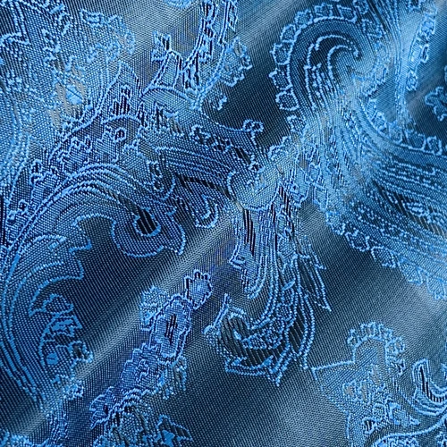 Intricate blue paisley jacquard fabric with elegant swirling patterns, perfect for upholstery or fashion design.