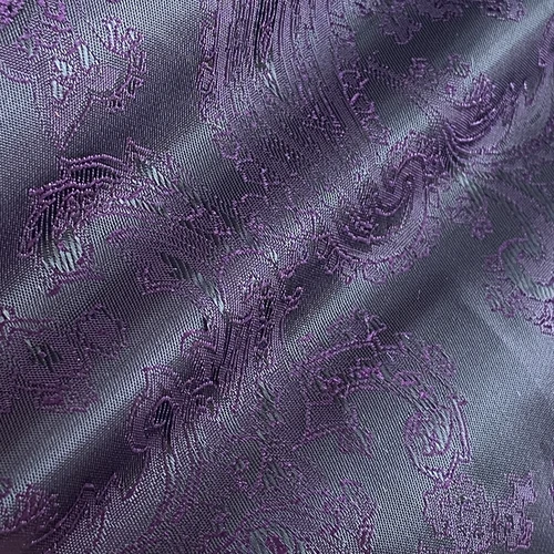 Intricate purple jacquard fabric featuring elegant swirling floral patterns. Perfect for luxury design or upholstery.