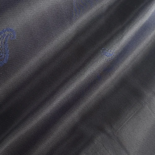 Close-up of dark blue fabric with a subtle paisley pattern, showcasing texture and detail in the weave.